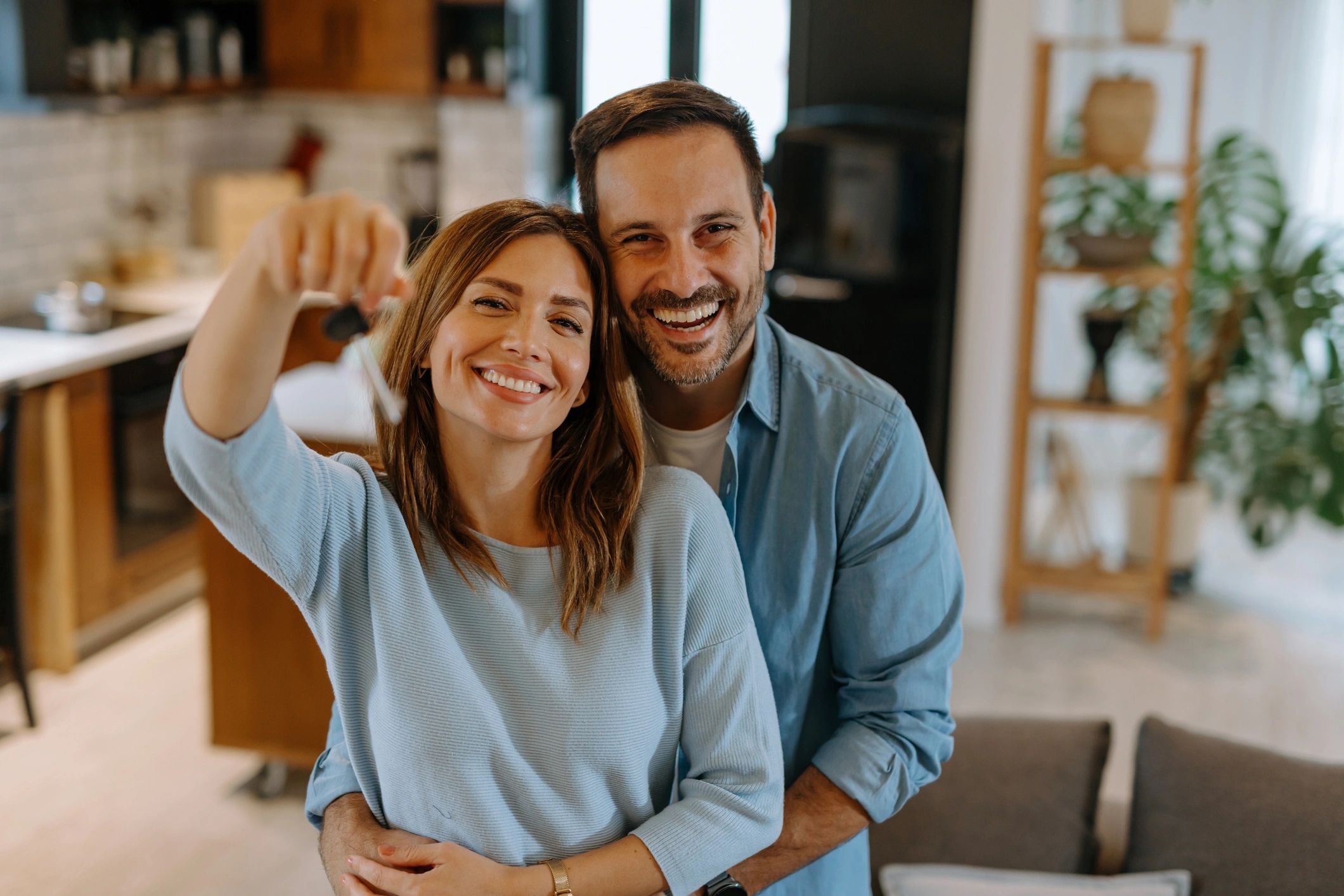 Happy couple receiving keys in a modern apartment